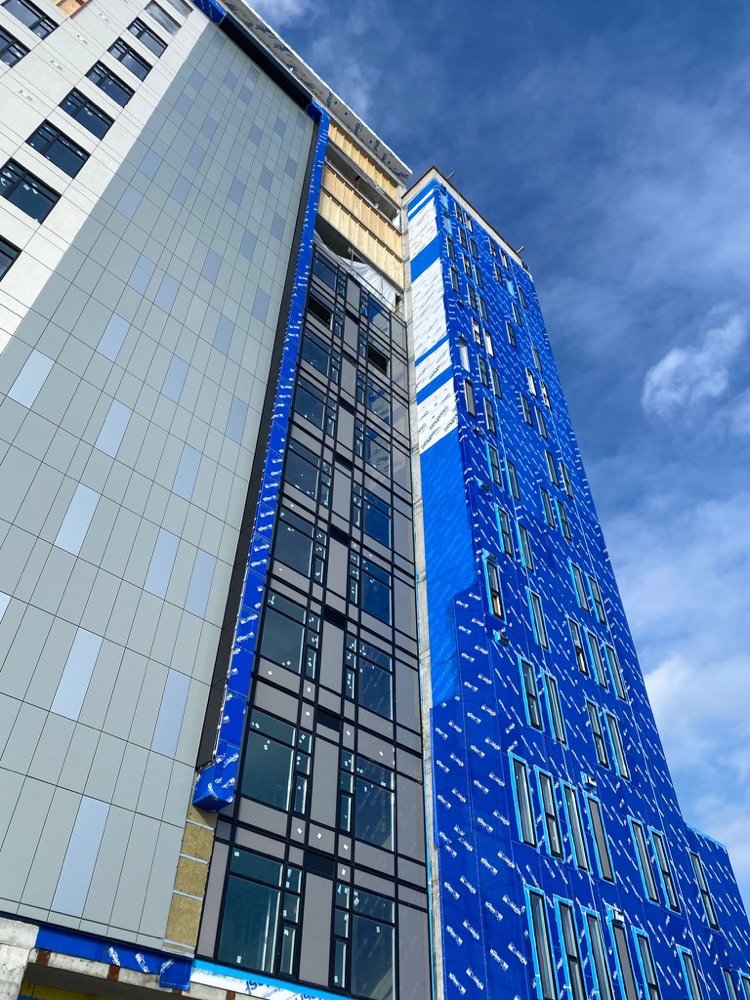 Looking up a mid-rise facade with new glazing being installed