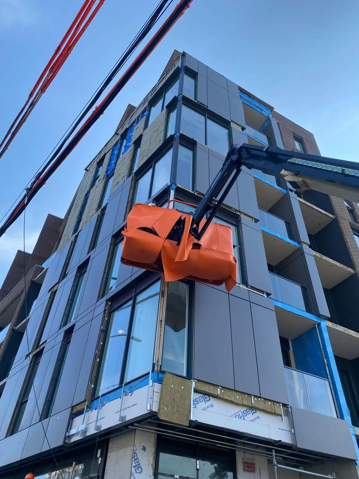 Boom lift basket working the facade during a glazing installation
