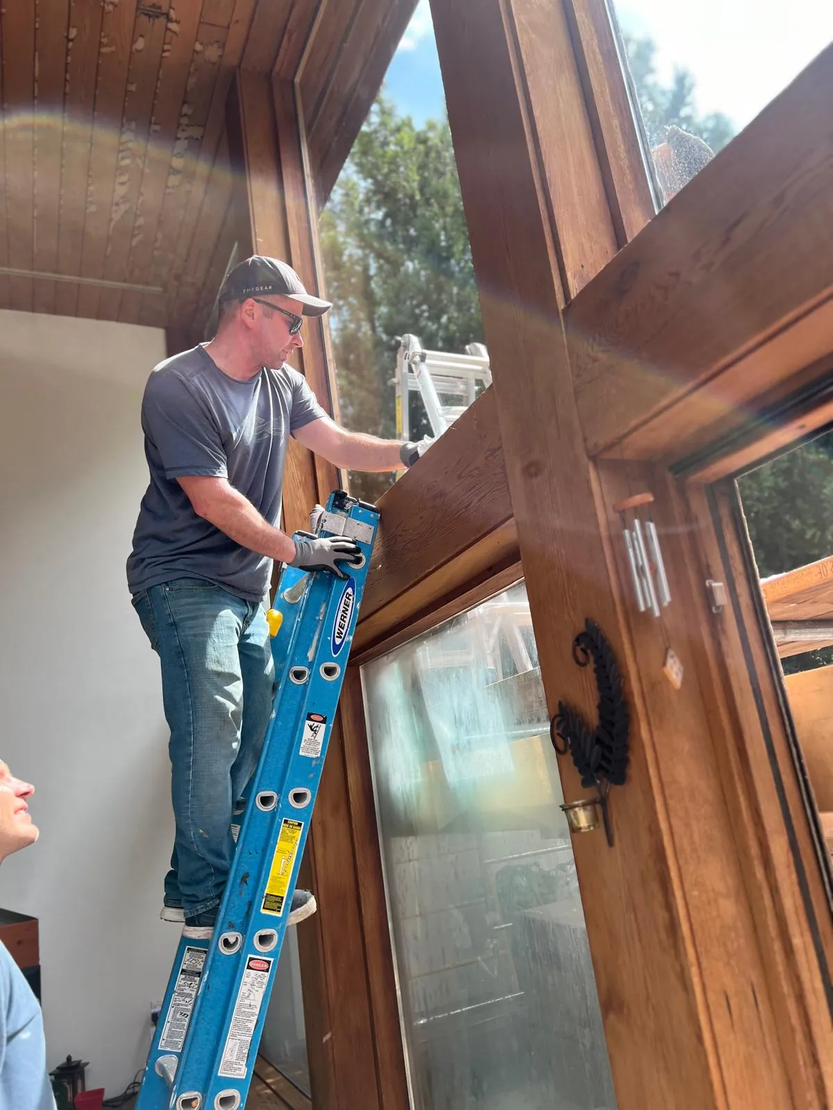 Installer fitting glass into a timber gable frame