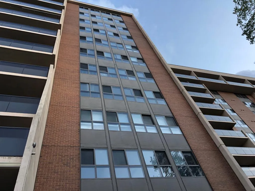 Brick and concrete apartment tower with replaced window wall glazing