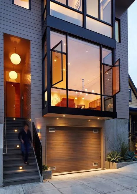 Modern home at dusk with warm light through new windows